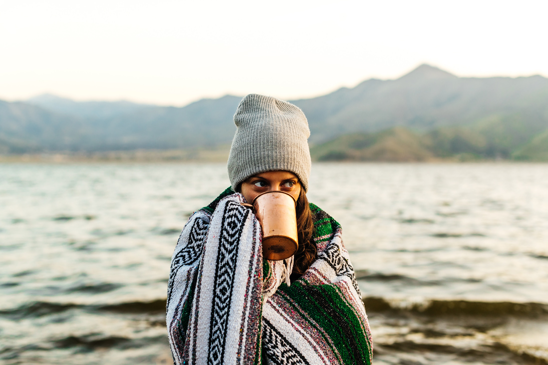 Woman with coffee at the beach
